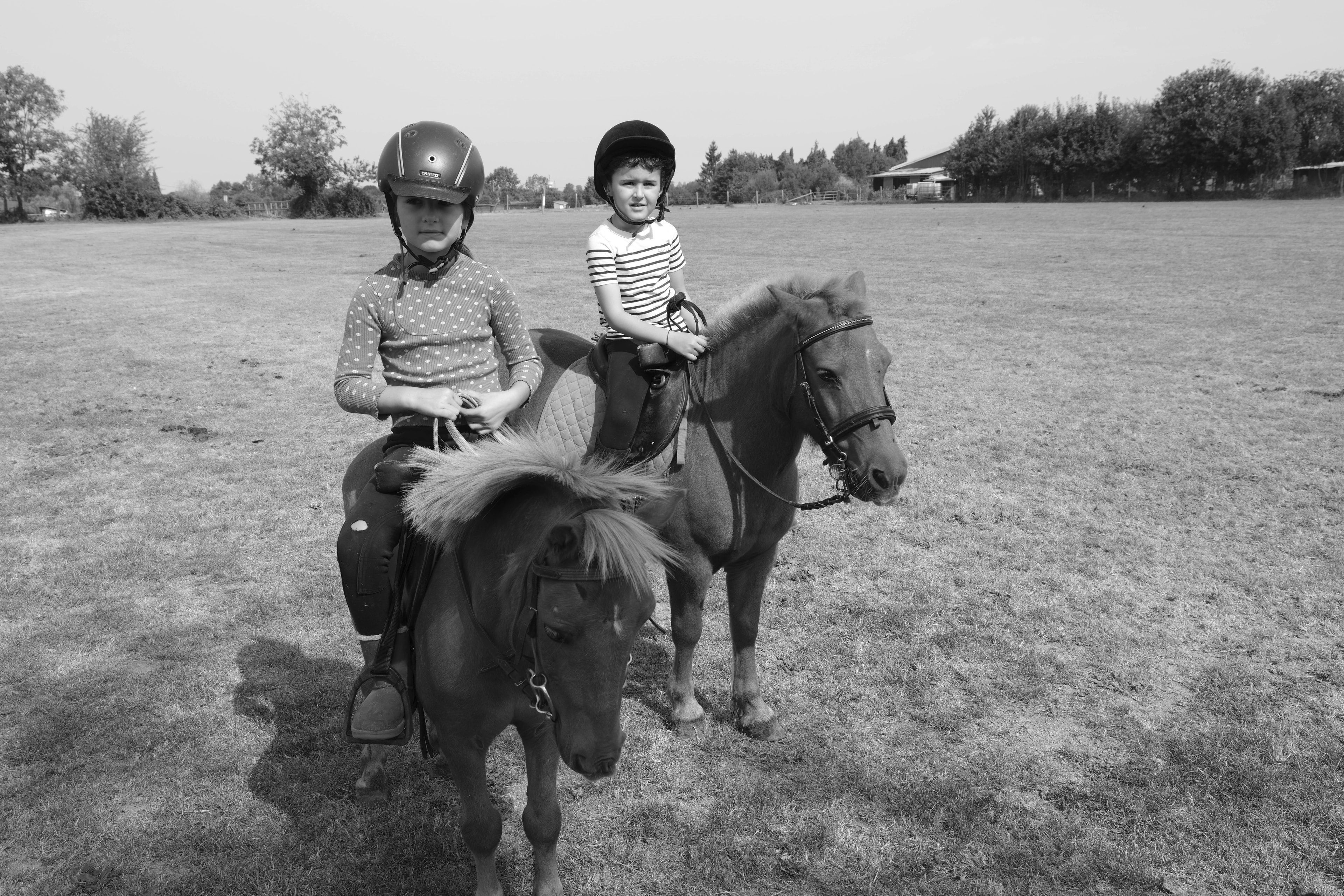 Two children on ponies, learning to ride at the polo grounds — Été à Saint-André-d'Hébertot, Normandy 2025